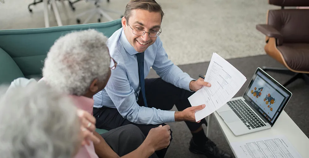 advisor showing documents to elderly man