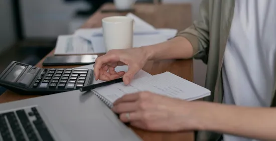 person working on their budget on table