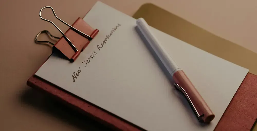 red notebook on table with resolutions list